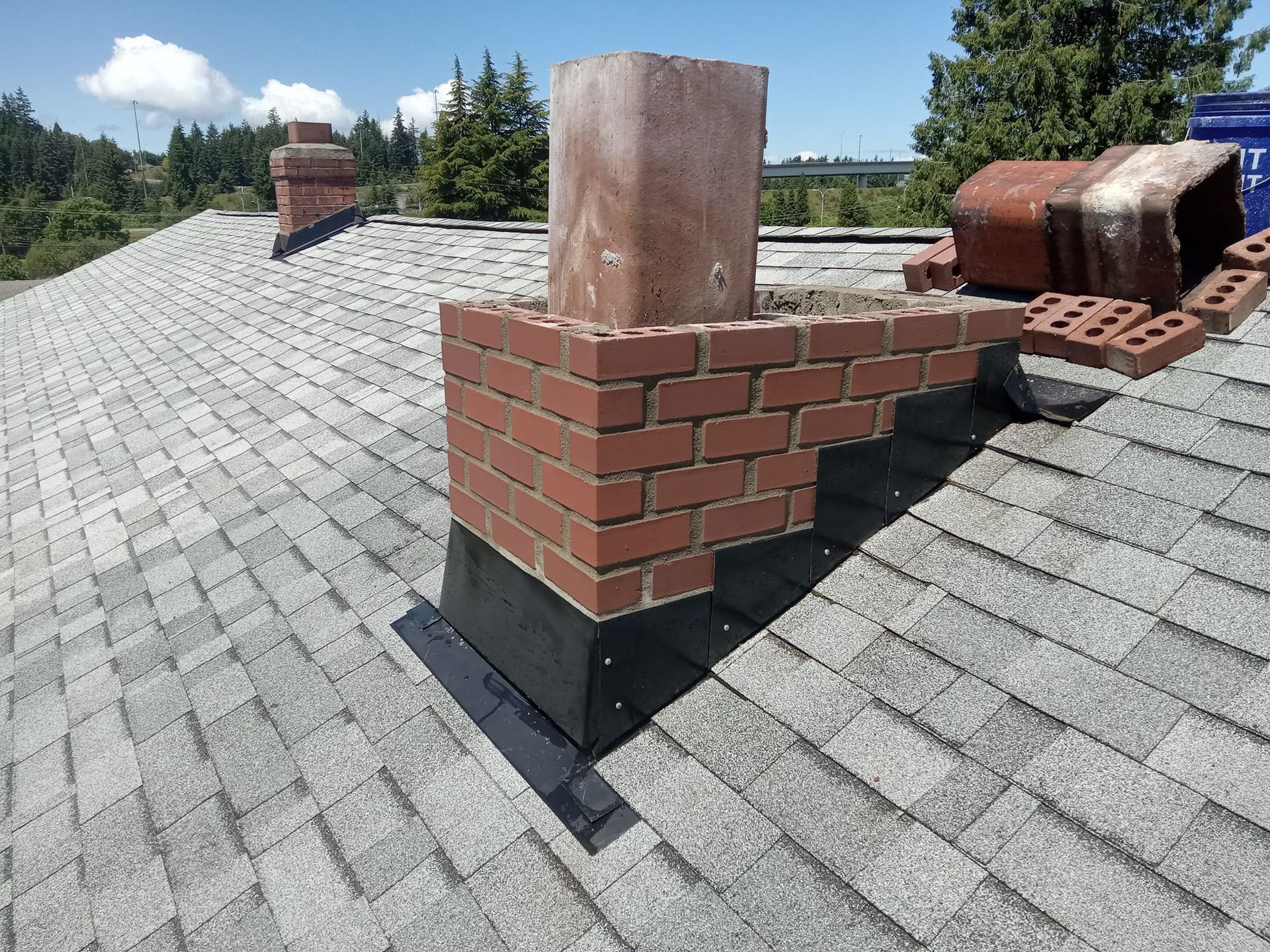 A brick chimney is sitting on top of a roof.