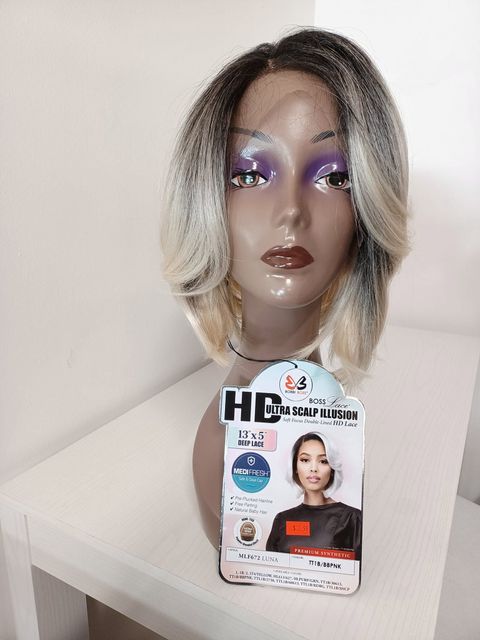 Mannequin head with shoulder-length blonde wig and purple makeup, next to a wig product card.