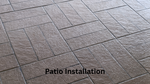 Gray patterned patio pavers laid in a diagonal pattern, with “Patio Installation” text overlaid.
