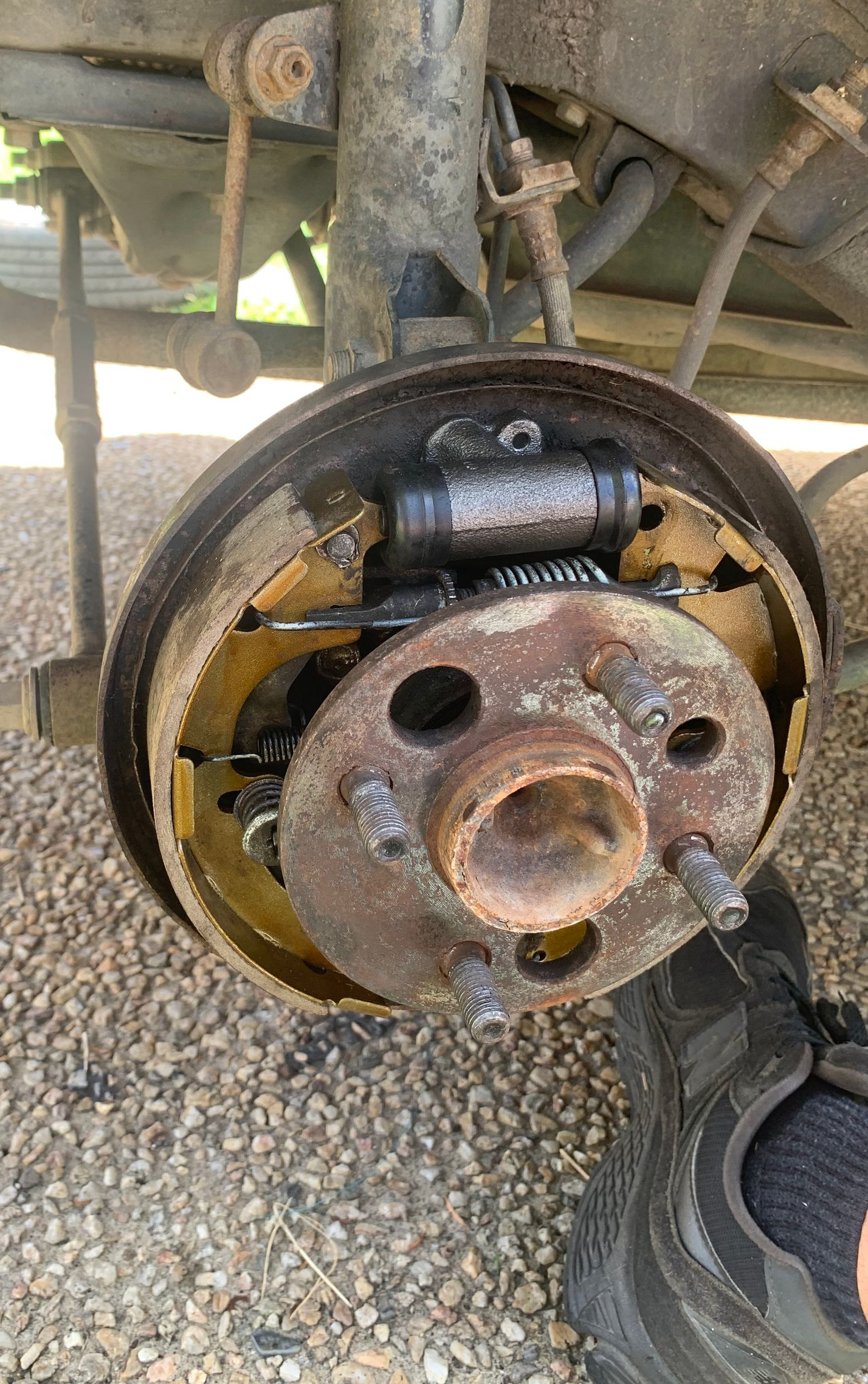 Rusty vehicle drum brake assembly with wheel removed, showing brake shoes and hub. — Calvin's Mobile Mechanics In Currumbin, QLD
