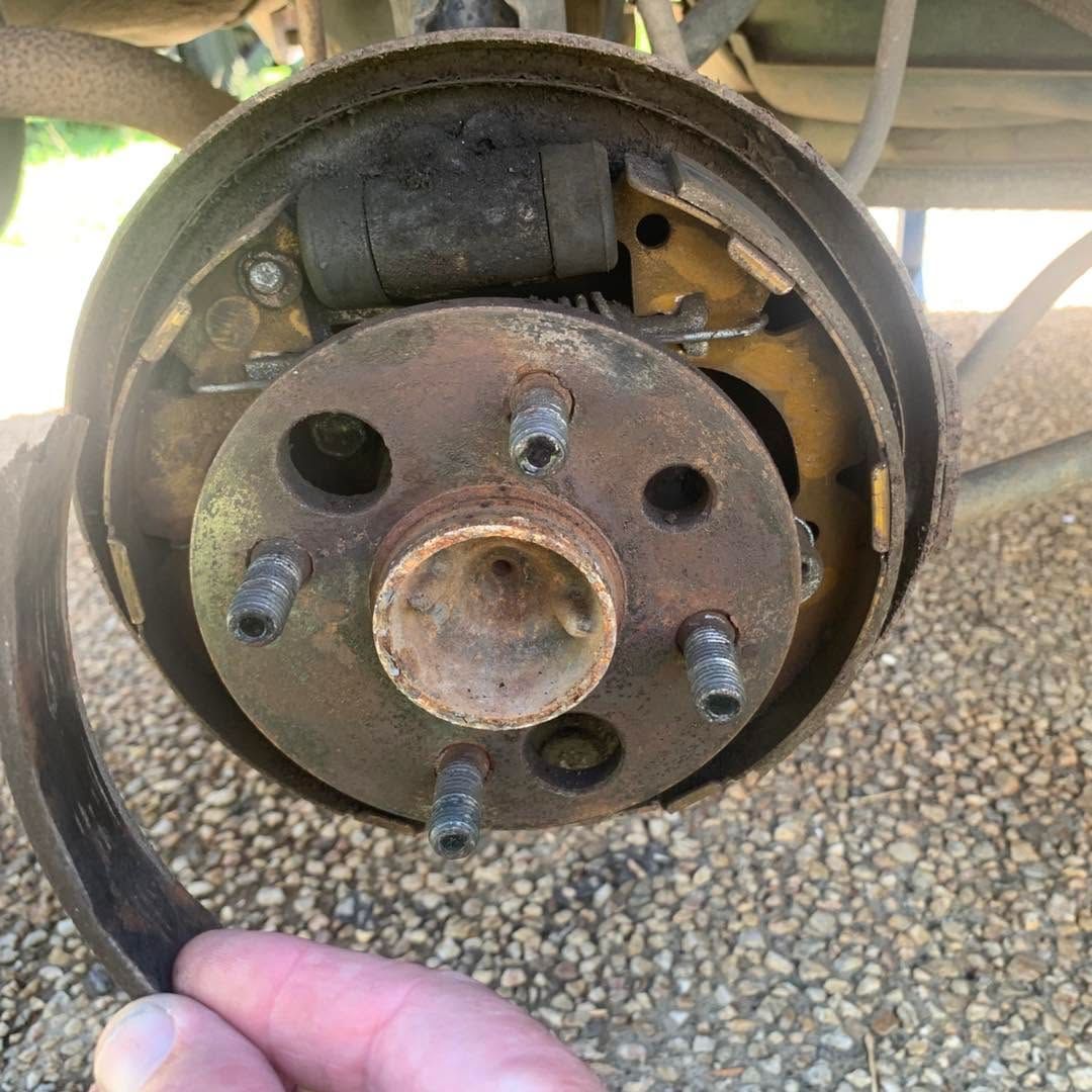 Close-up of a car brake drum and hub with wheel studs, showing the exposed brake assembly.  — Calvin's Mobile Mechanics In Elanora, QLD