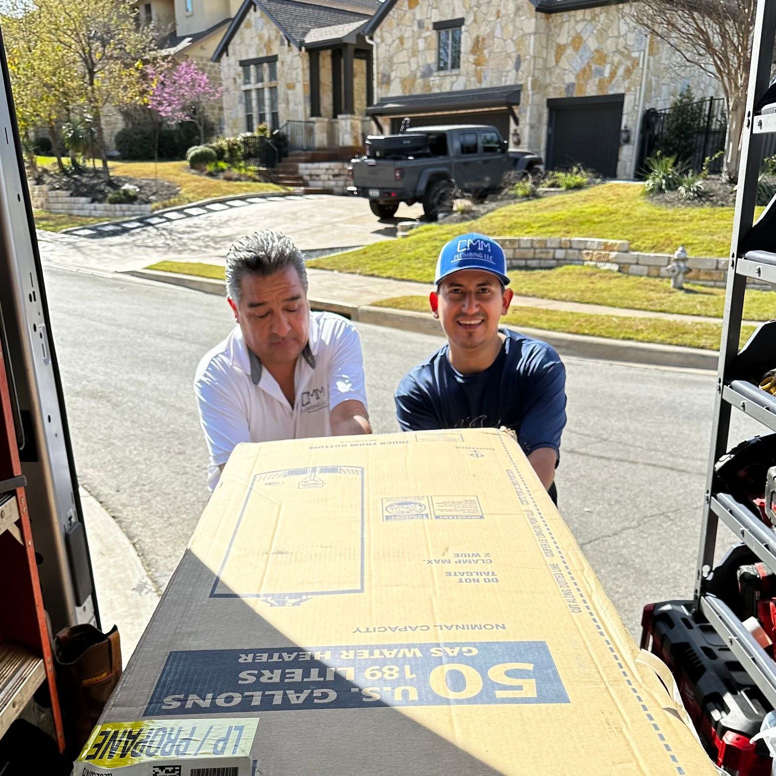 two men are looking at a box that says 50 gallons on it