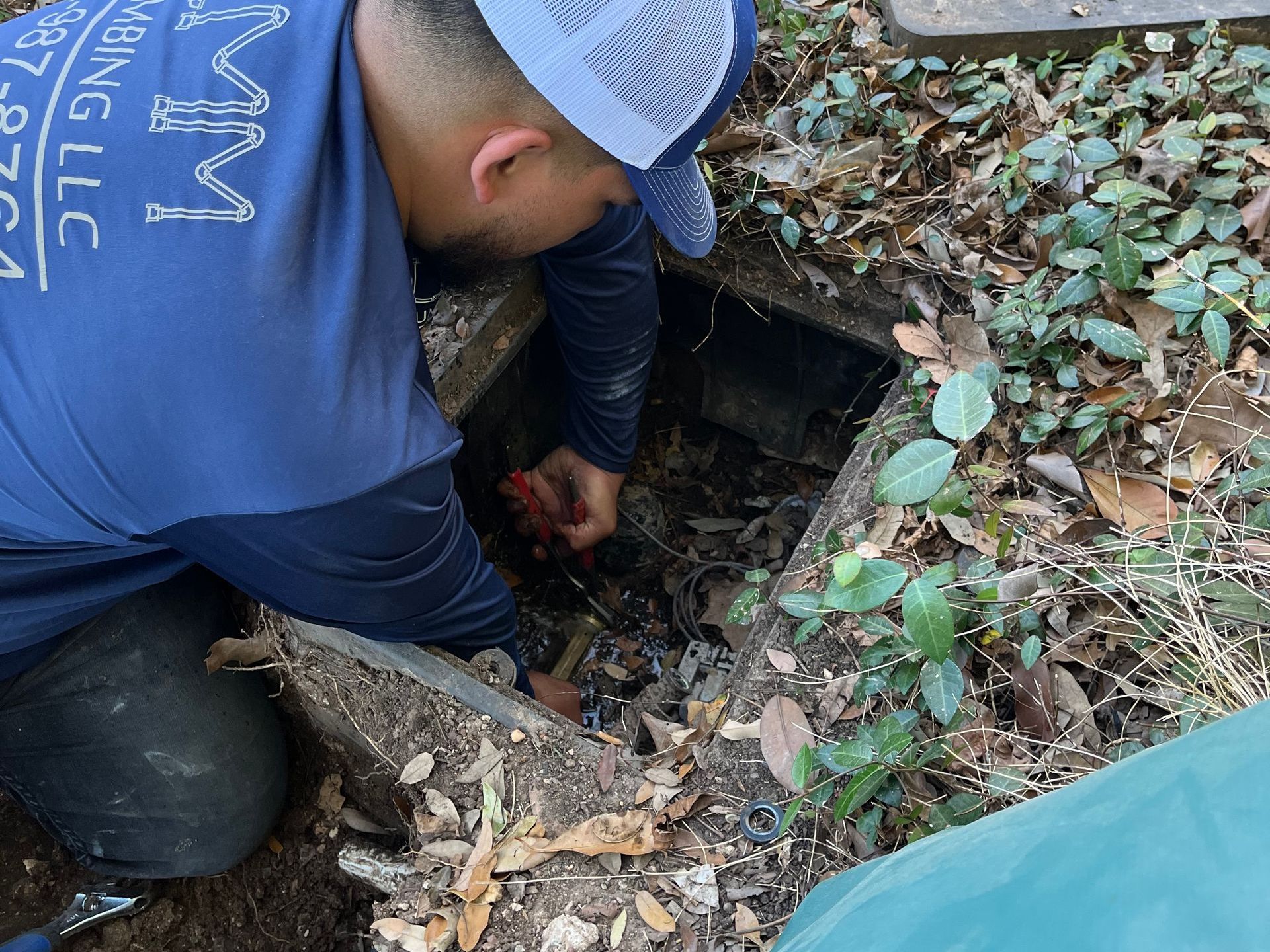 a man in a blue shirt is kneeling down in the dirt .