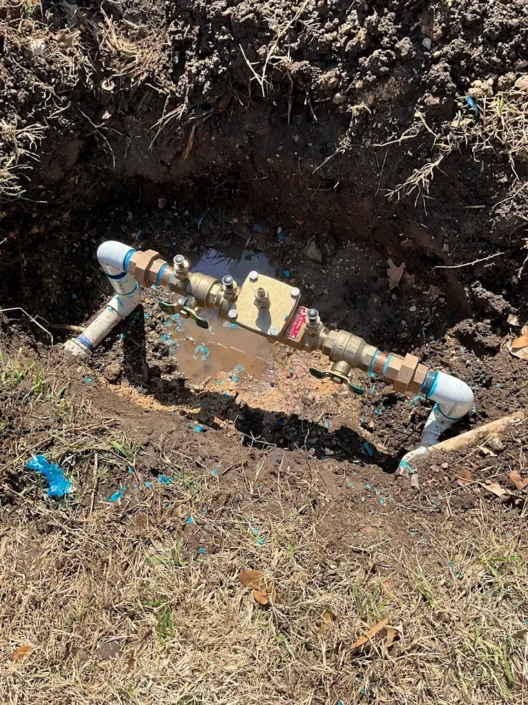 Exposed pipe leak in a backyard showing the need for professional leak detection service