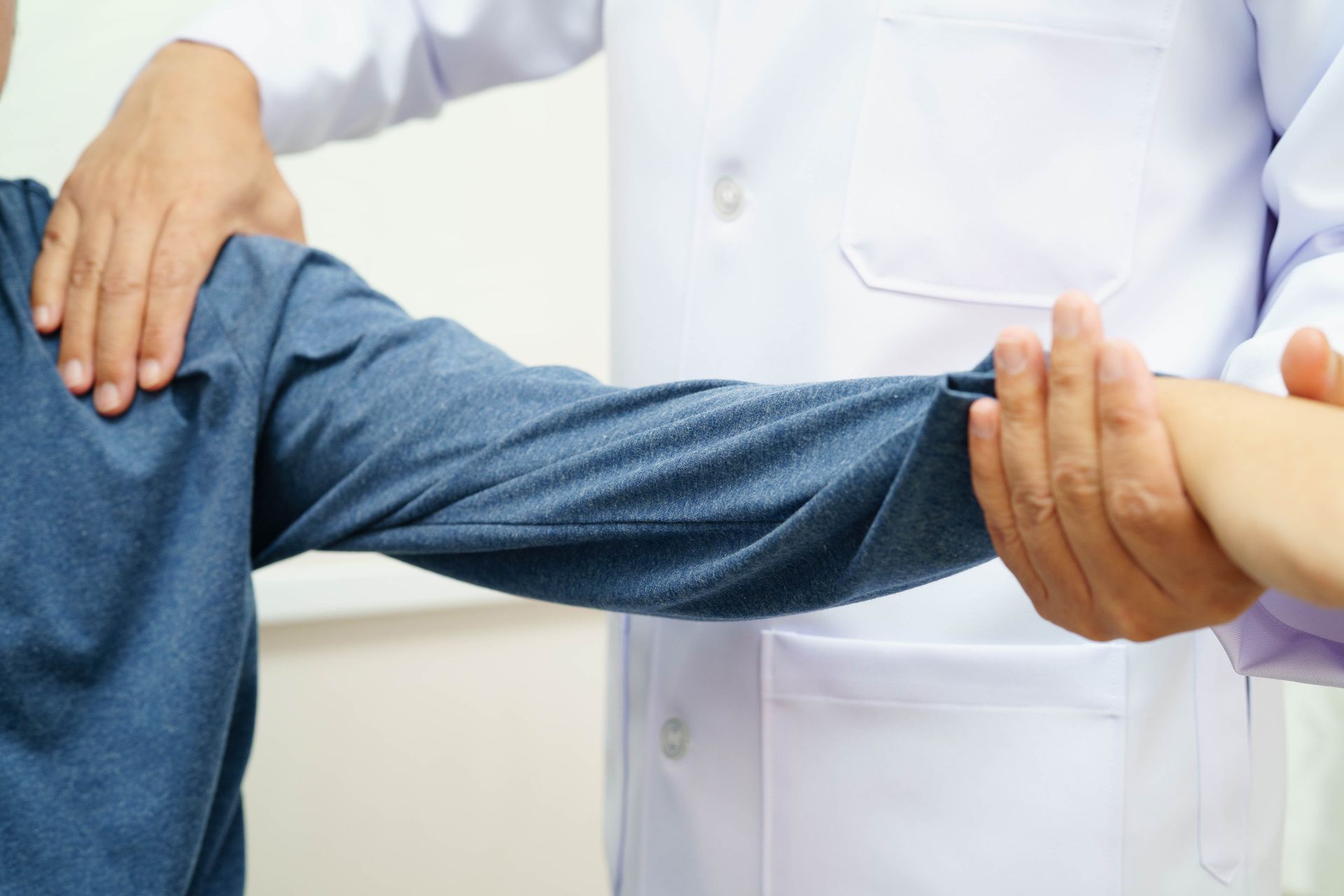 Physical therapist performing shoulder and arm range of motion examination on patient. Physical therapist performing shoulder and arm range of motion examination on patient.