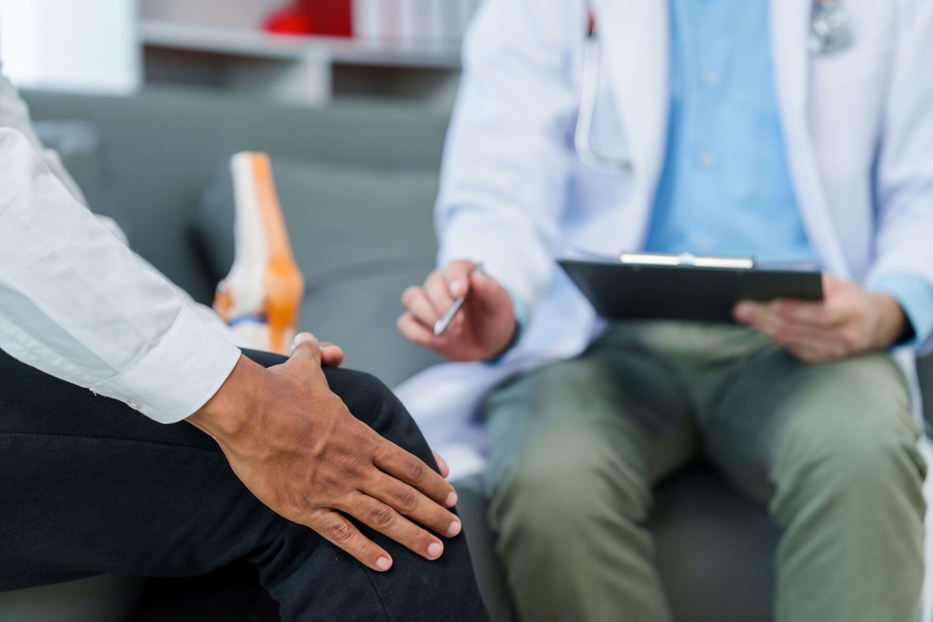Doctor consulting patient, showcasing chronic pain management physician addressing knee discomfort. Doctor consulting patient, showcasing chronic pain management physician addressing knee discomfort.