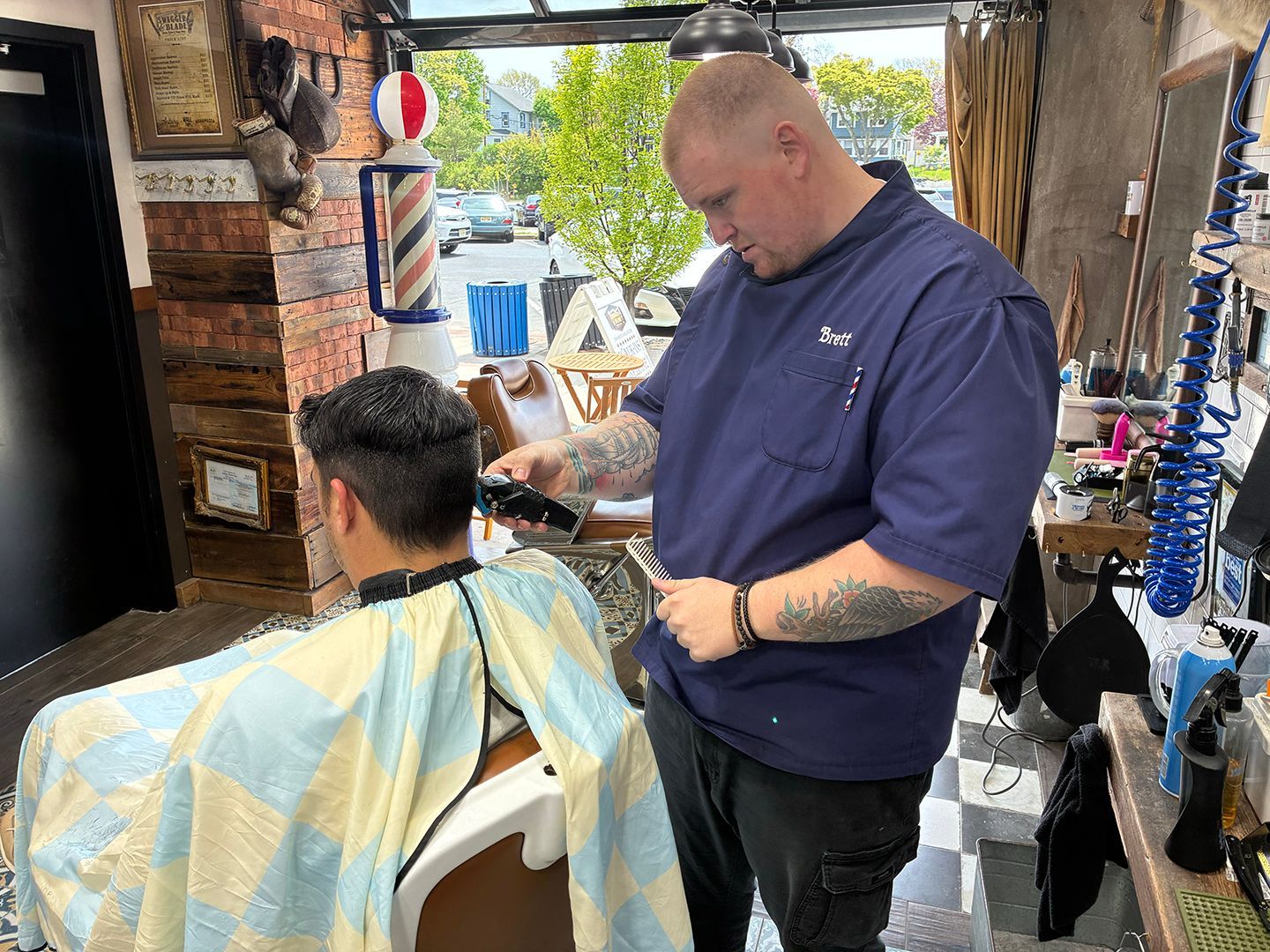 Professional barber providing a precision men's haircut at Swagger & Blade barbershop in Monmouth County, NJ.