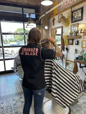 Barber providing professional men's grooming services inside Swagger & Blade barbershop in Monmouth County, NJ.