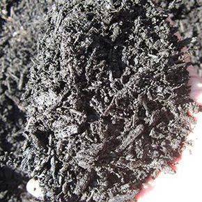 Close-up of black mulch; small wood pieces and some texture visible.