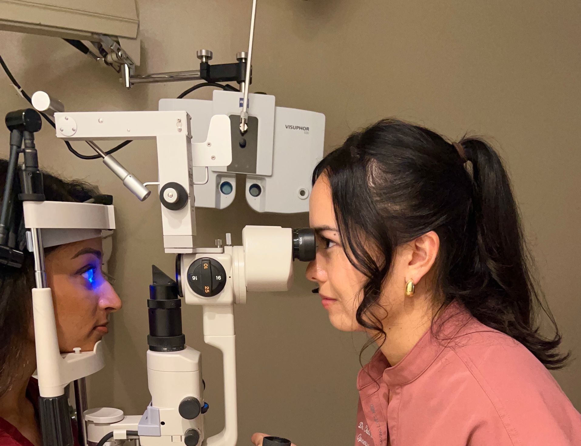 A woman is getting her eyes examined by an ophthalmologist