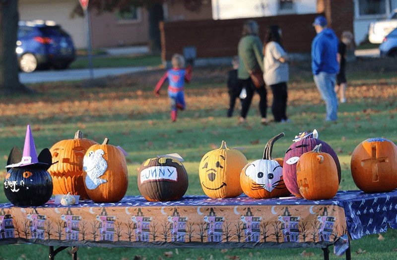 Decorated pumpkins on a table at an outdoor Halloween event. Extended Care | Immanuel Lutheran School | Belvidere, IL