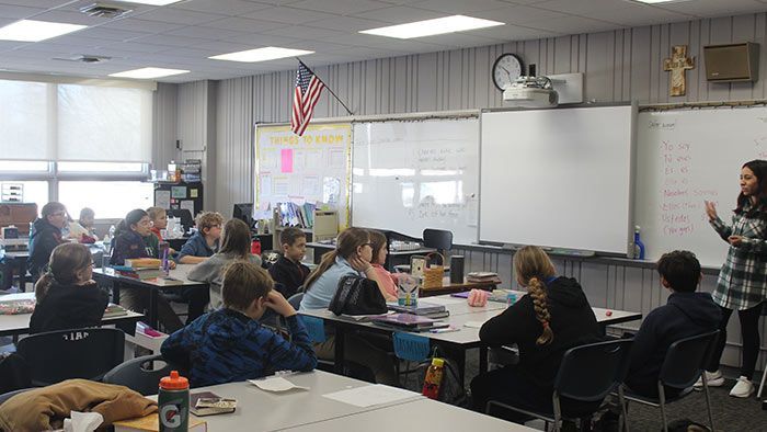 Students in classroom with teacher at whiteboard, American flag on wall. NWEA Test Scores | Immanuel Lutheran School | Belvidere, IL