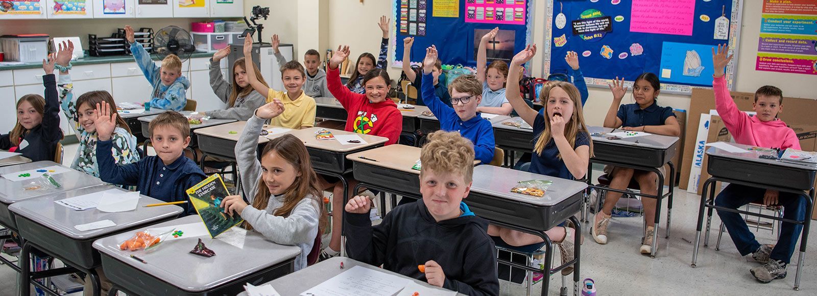 Classroom of students with hands raised, answering a question. NWEA Test Scores | Immanuel Lutheran School | Belvidere, IL