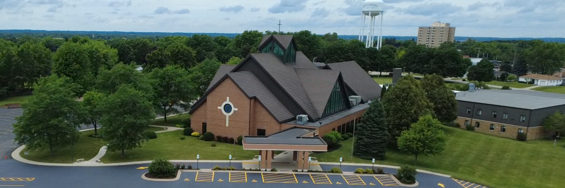 A brick church with a brown roof sit among trees. Discipleship | Immanuel Lutheran School | Belvidere, IL