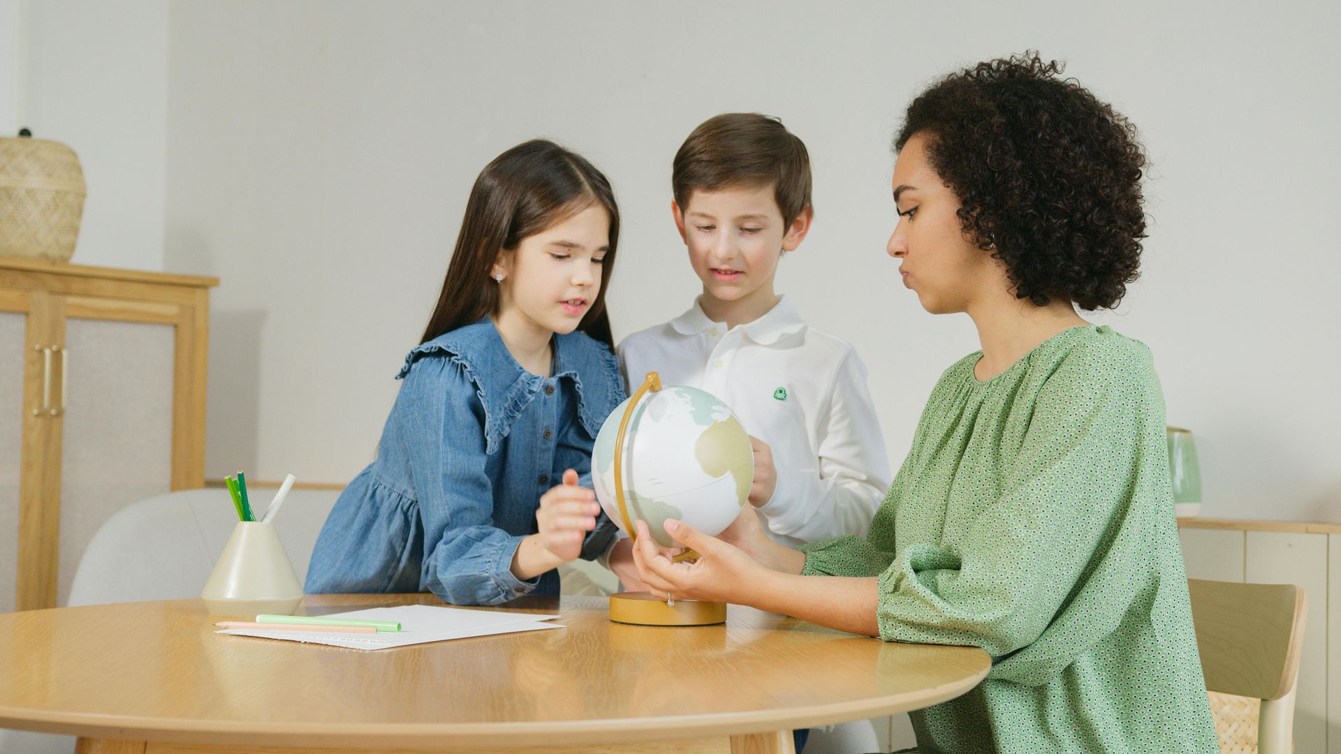 Teacher showing students a globe in a classroom. The Immanuel Difference | Immanuel Lutheran School | Belvidere, IL