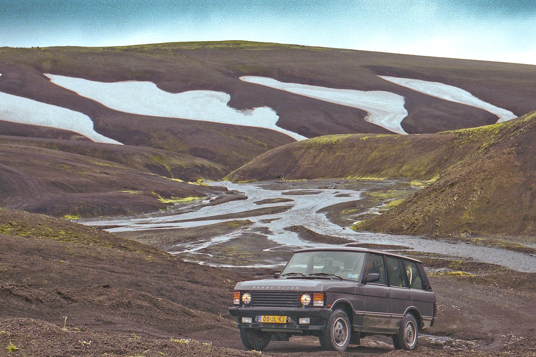 Een range rover rijdt over een onverharde weg