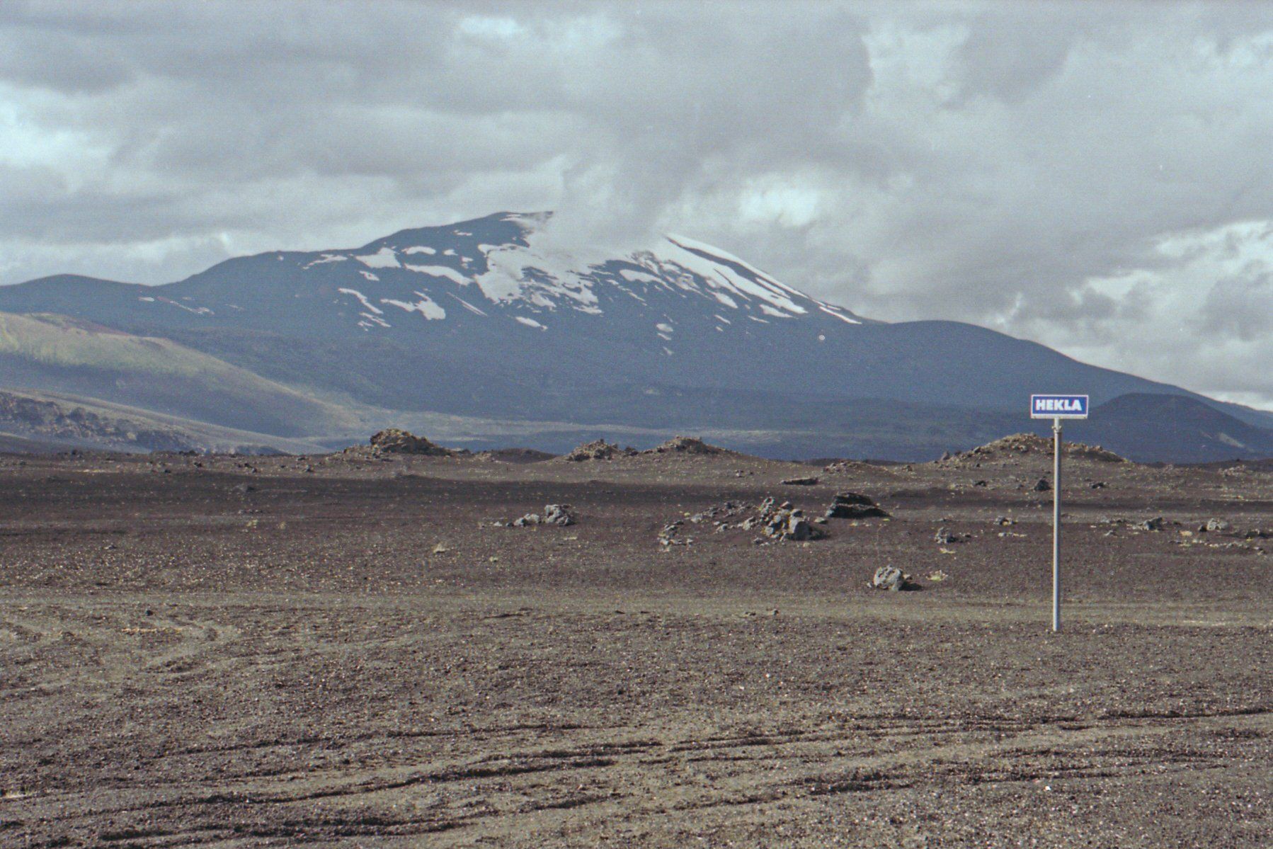 Een bord midden in de leegte van IJsland met bergen op de achtergrond