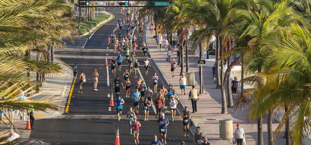 Runners and spectators celebrating at the beachfront finish