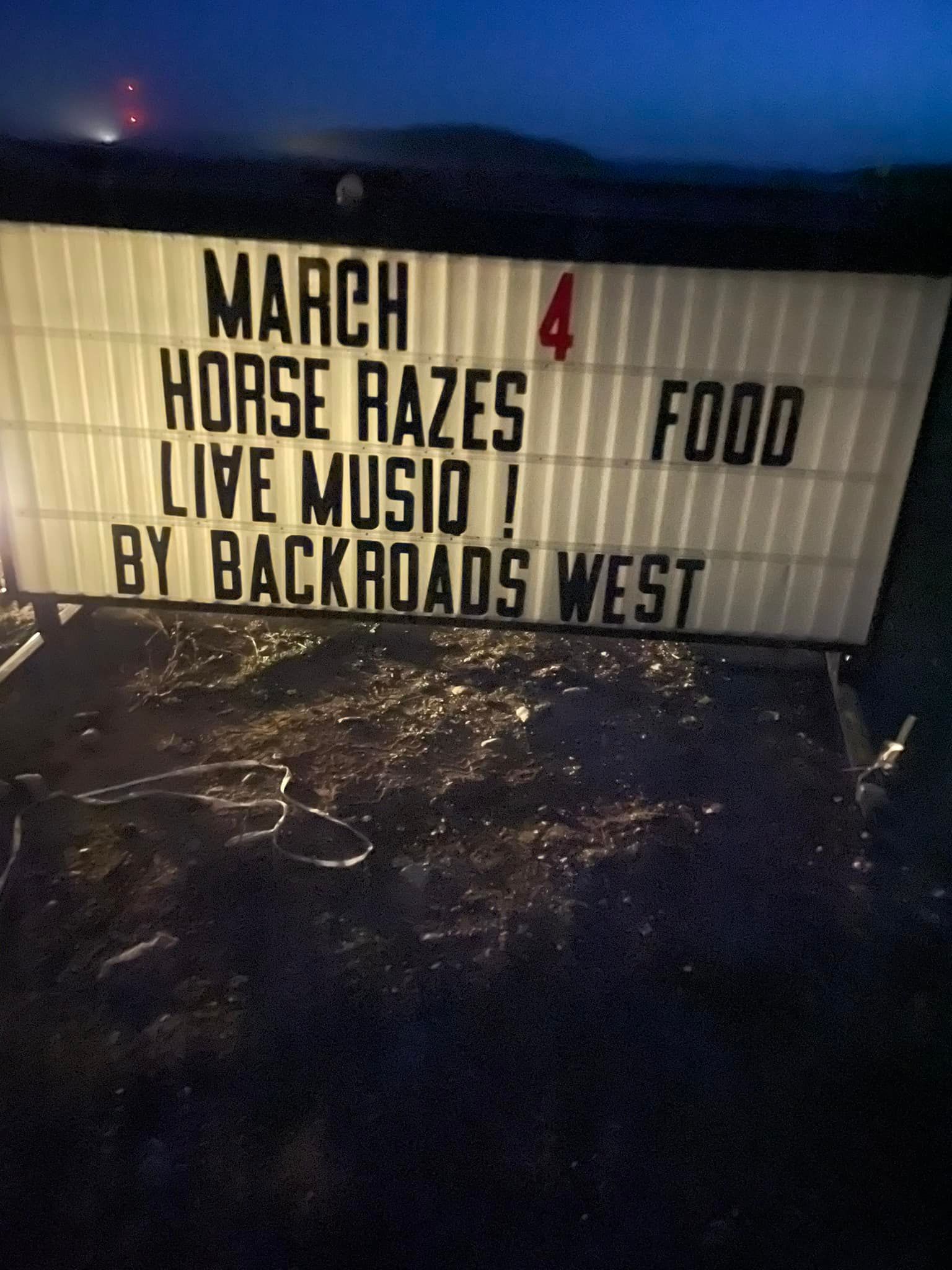 Marquee sign at night reads “March 4 Horse Races, Live Music by Backroads West, Food”
