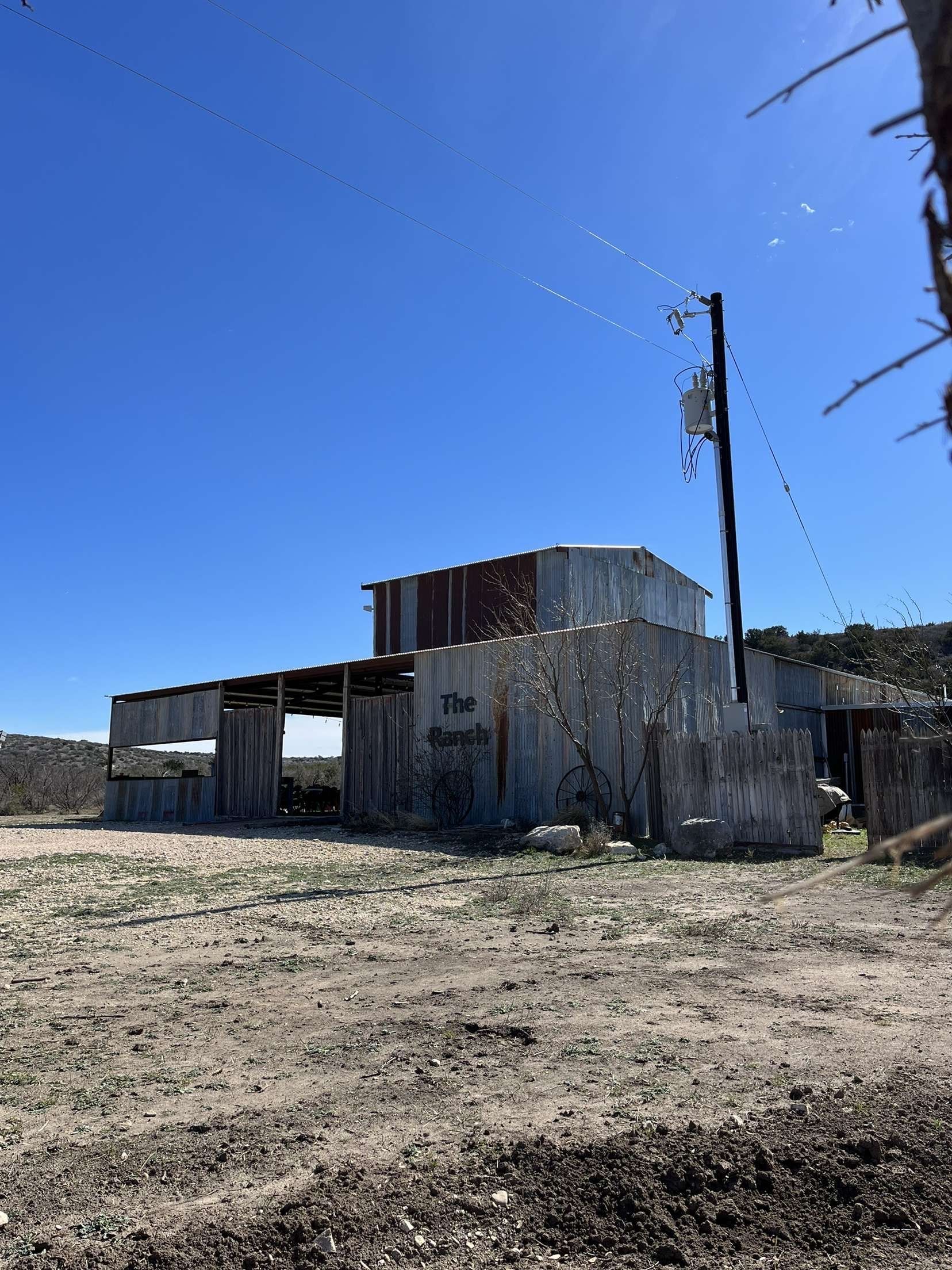Abandoned concrete building in a dry field under a clear blue sky