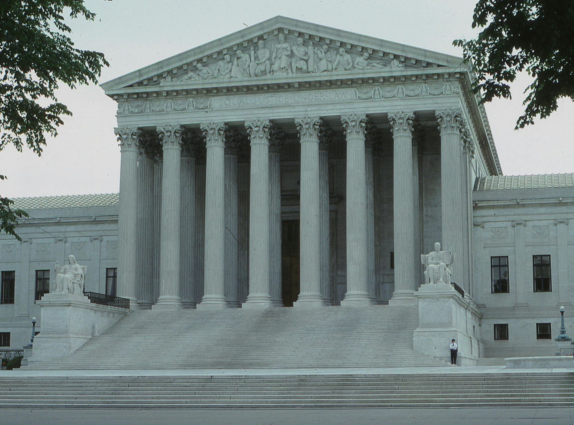 U.S. Supreme Court building with tall columns and steps, framed by trees