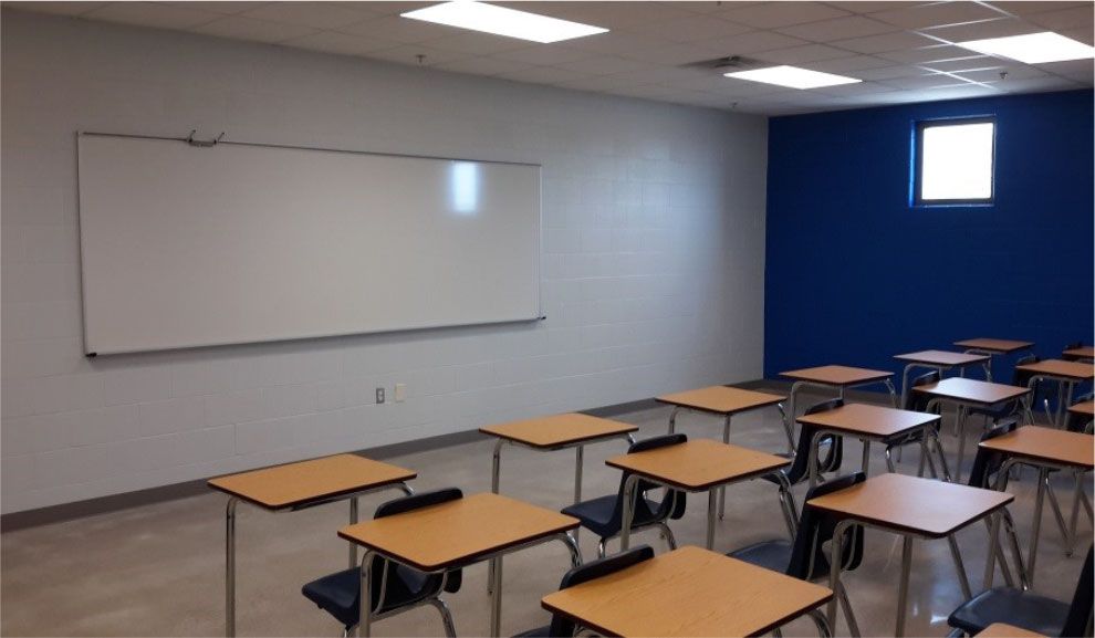 A classroom with wooden desks and a white board