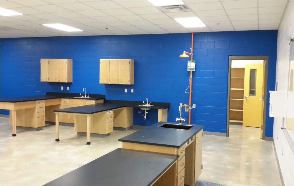 An empty lab with blue walls and black counter tops