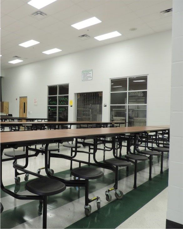 An empty school cafeteria with tables and chairs