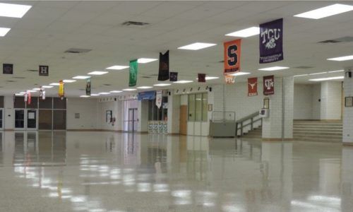 An empty hallway with tcu and texas flags hanging from the ceiling