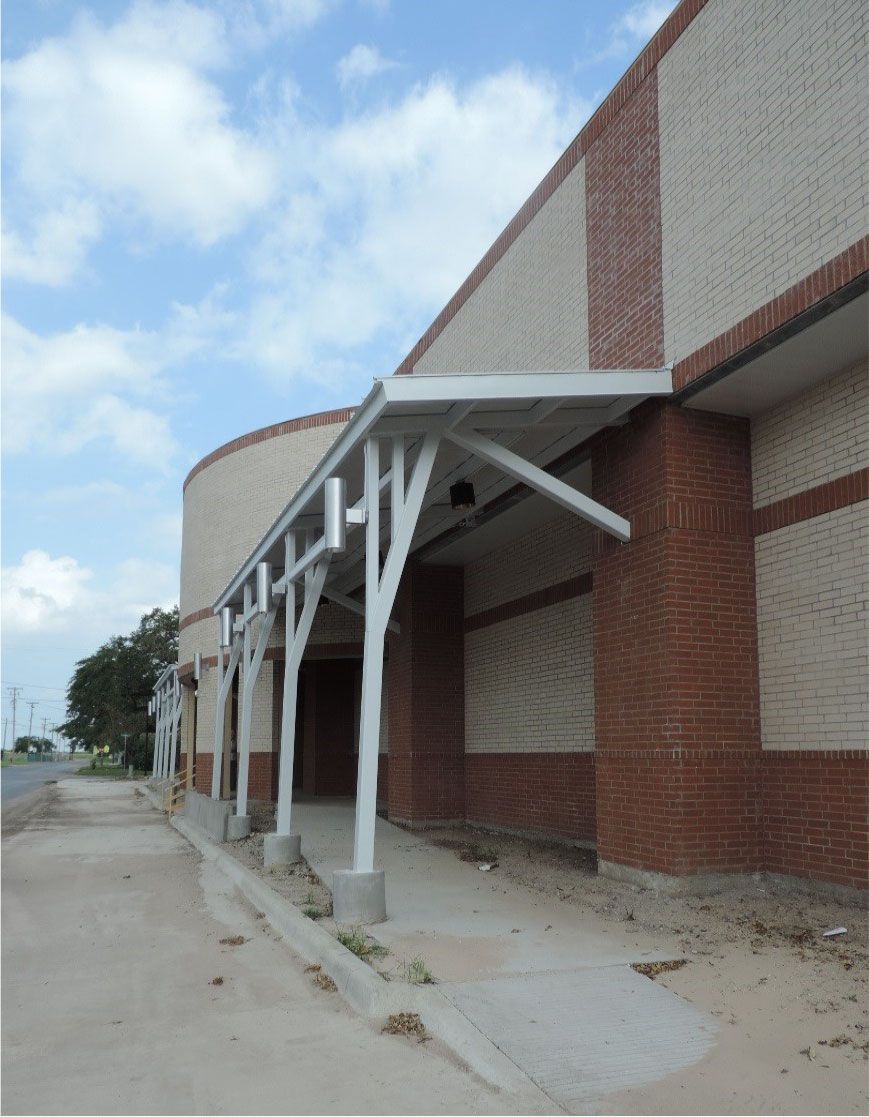 A brick building with a white canopy over the entrance