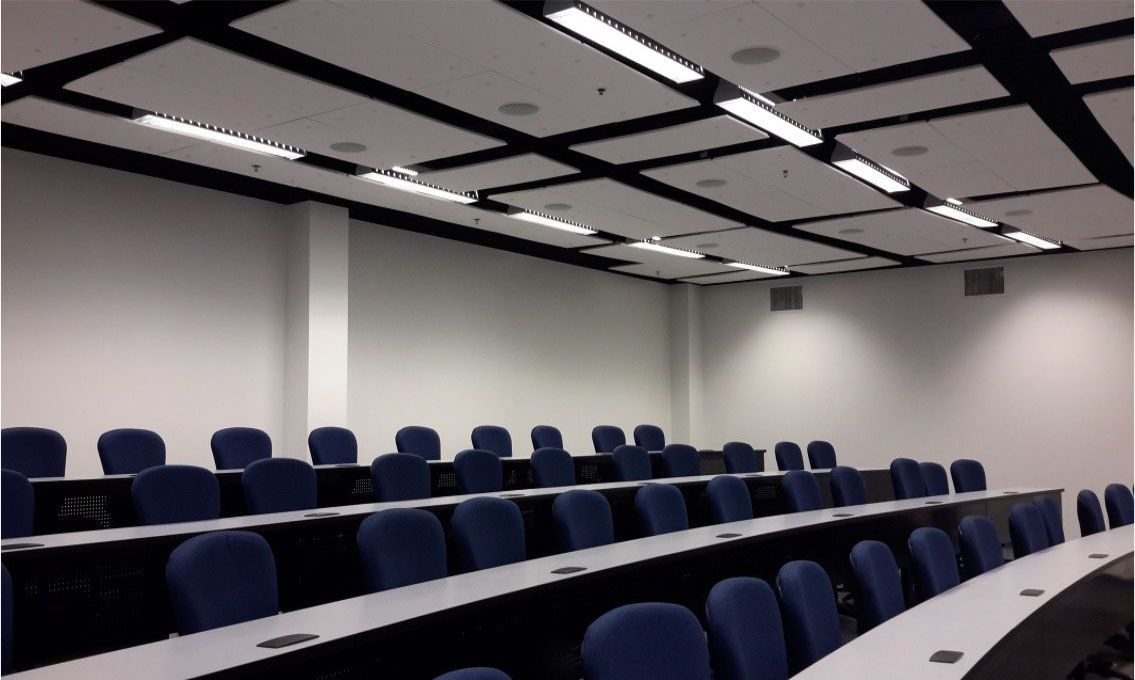 A conference room with long tables and blue chairs