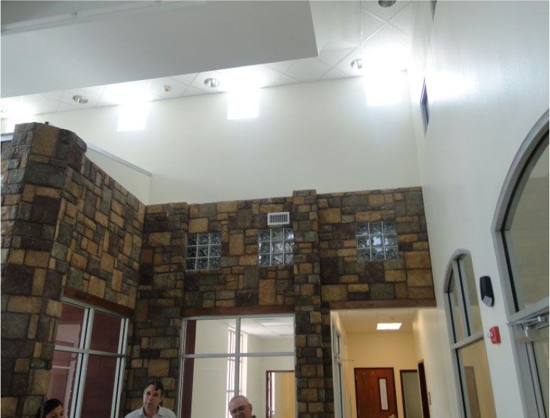 A group of people are sitting in a room with a stone wall