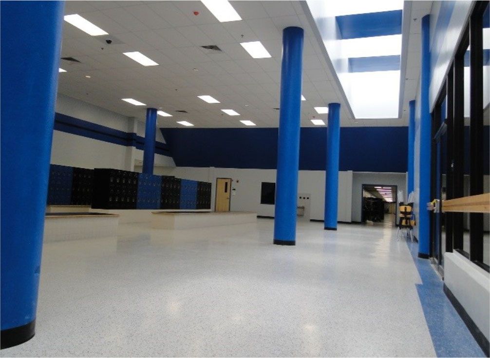 An empty hallway with blue columns and lockers