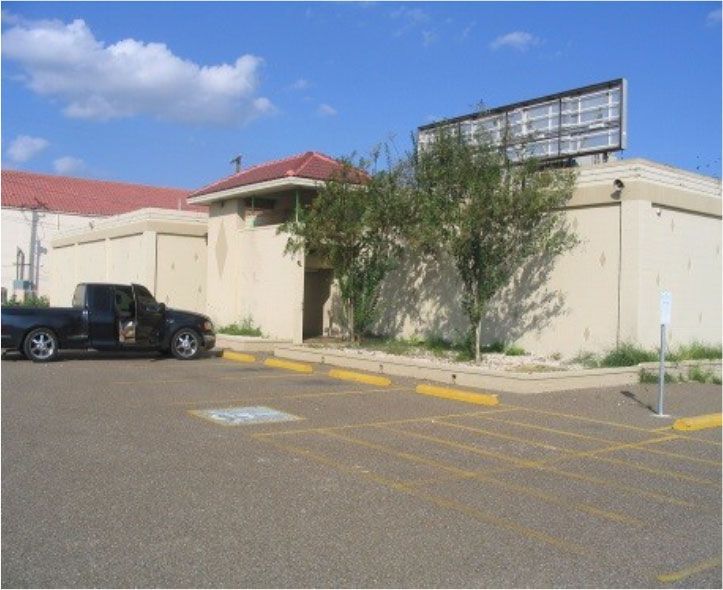 A black truck is parked in front of a building