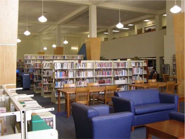 A library with a blue couch and chairs