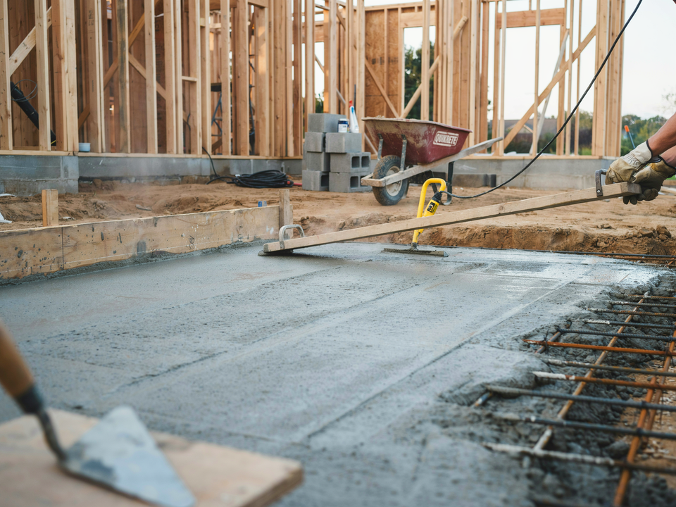 A ladder is sitting in front of a house under construction.