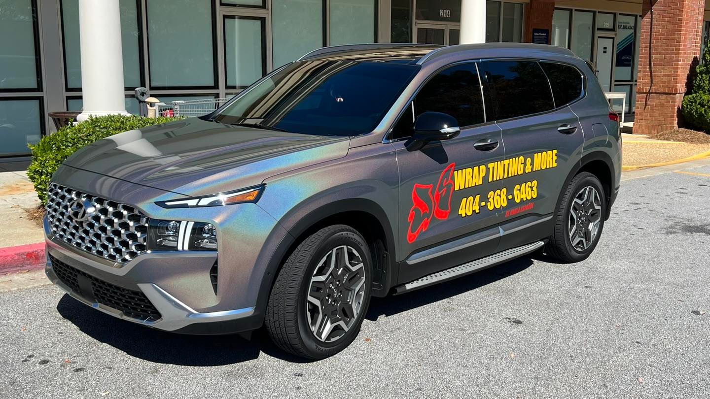 A gray suv is parked in front of a building.