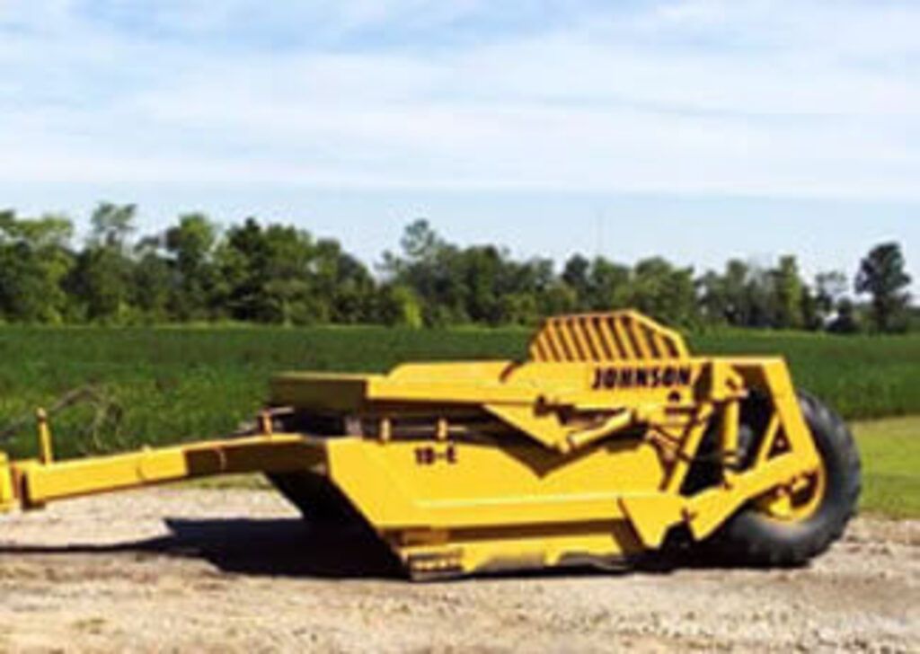 A yellow johnson tractor is parked in a field