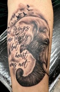 A person has a tattoo of an elephant with a quote on it.