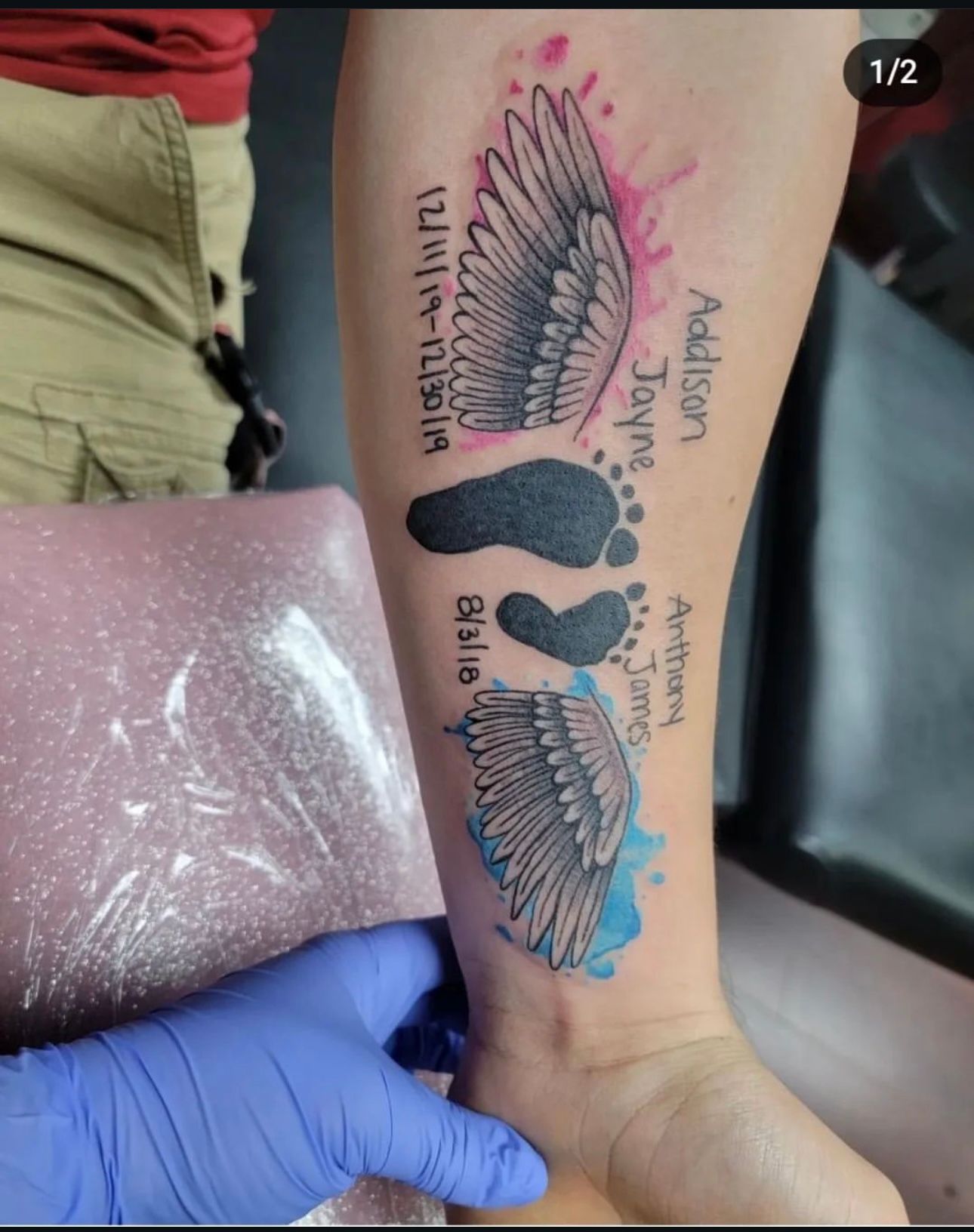 A tattoo of a baby 's footprints and wings on a person 's arm