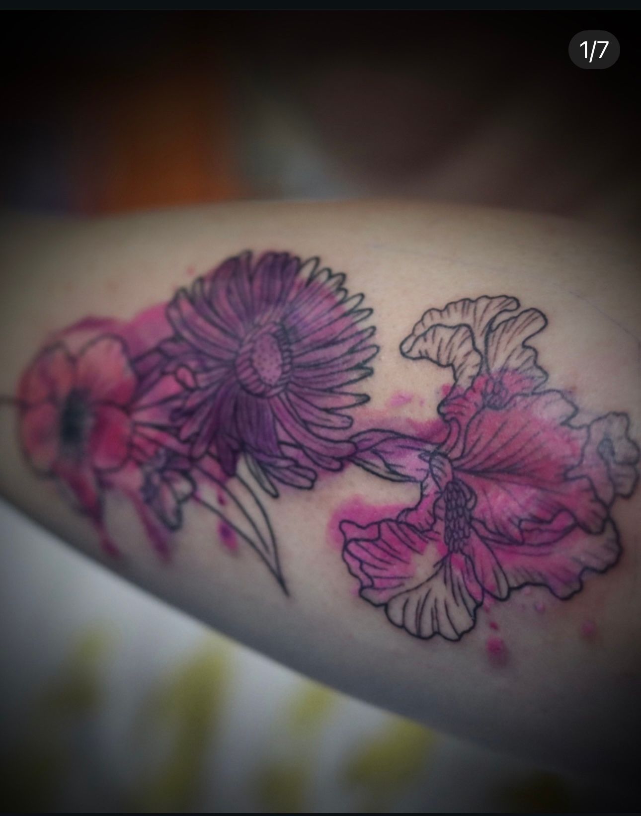 A tattoo of purple flowers on a person 's arm