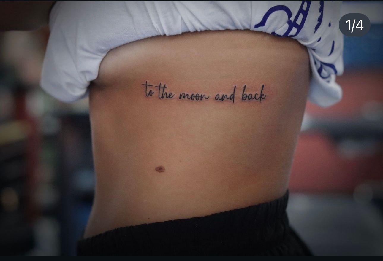 A woman has a tattoo on her side that says to the moon and back