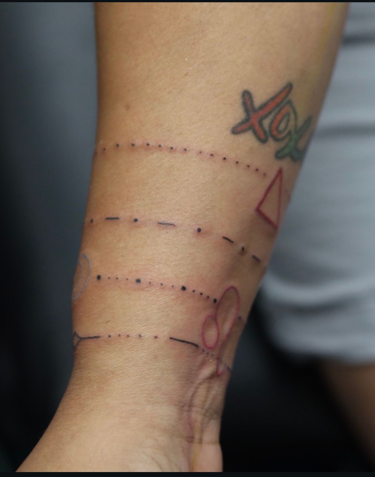 A person has a tattoo on their arm that says xoxo