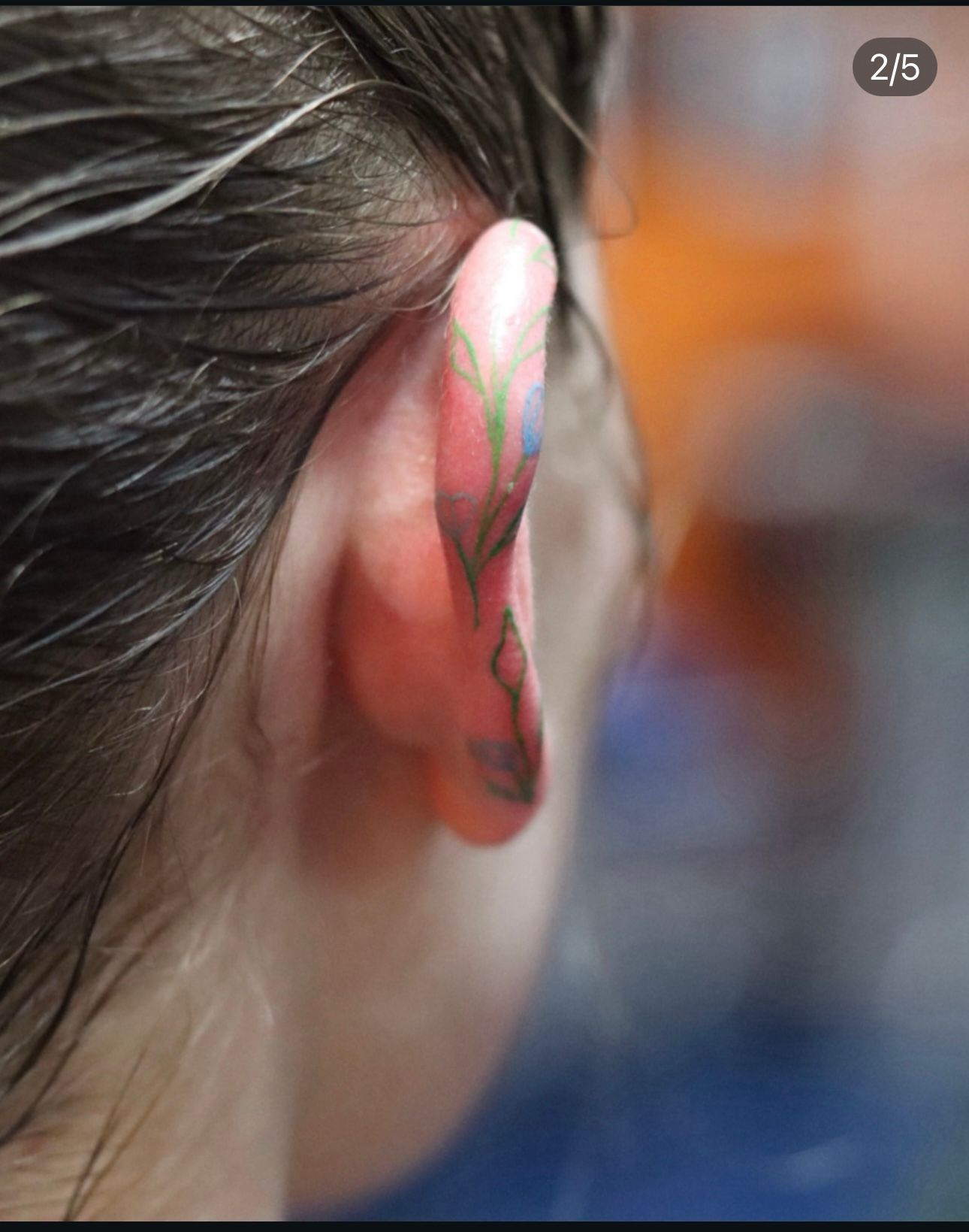A close up of a person 's ear with a tattoo on it