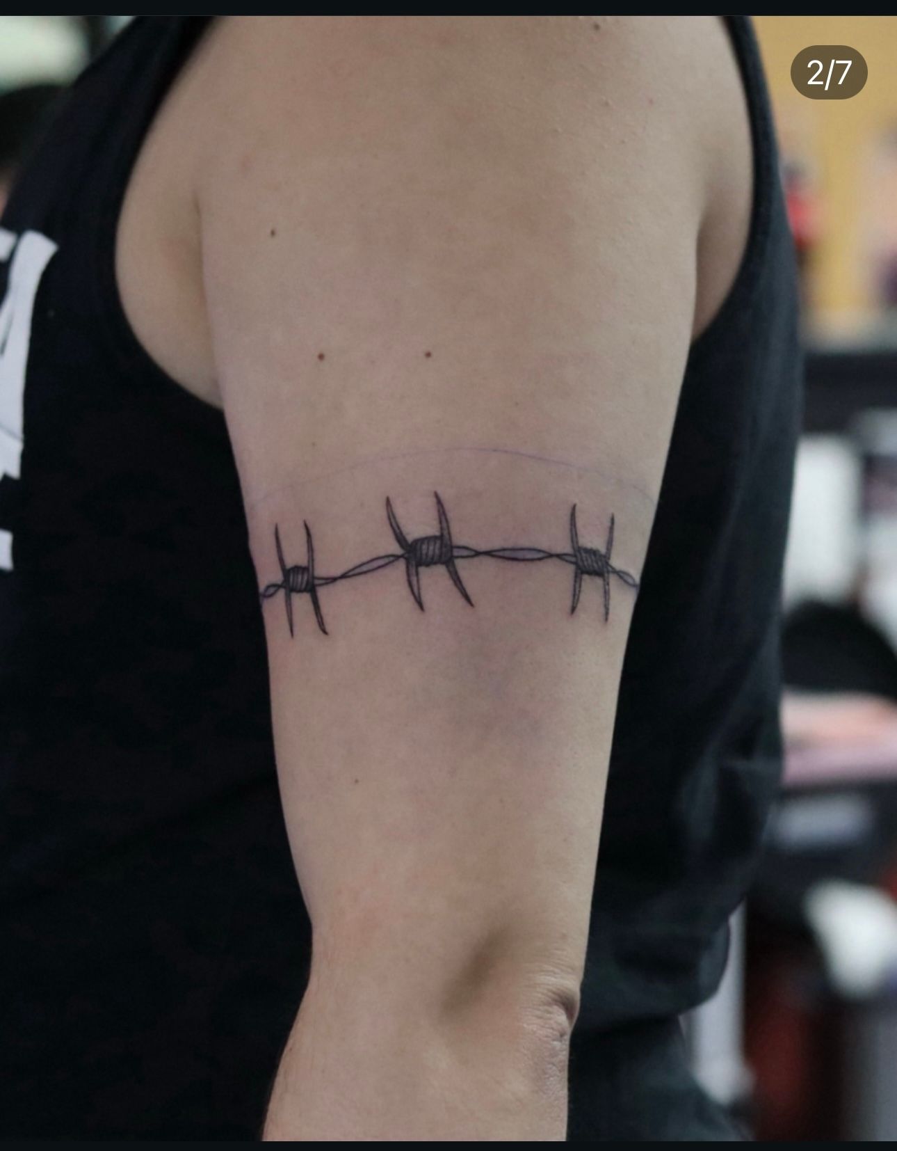 A person has a barbed wire tattoo on their arm