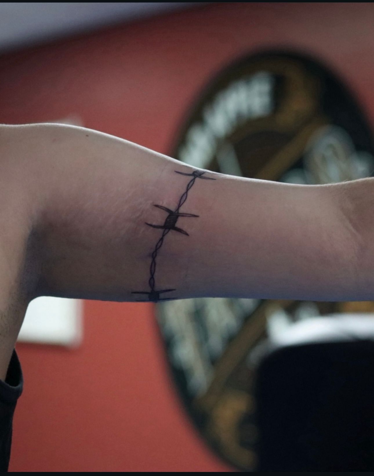 A person has a tattoo on their arm that says 