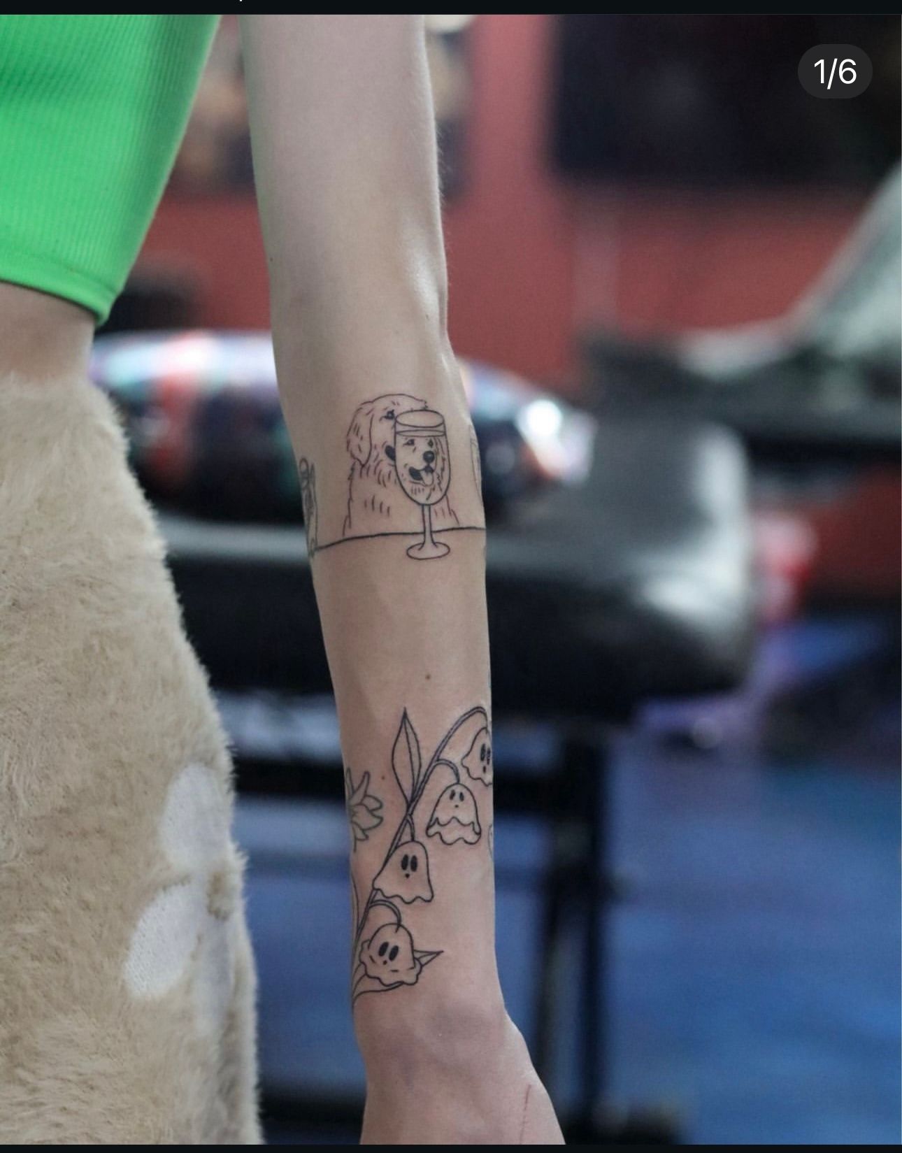 A woman is getting a tattoo on her forearm.
