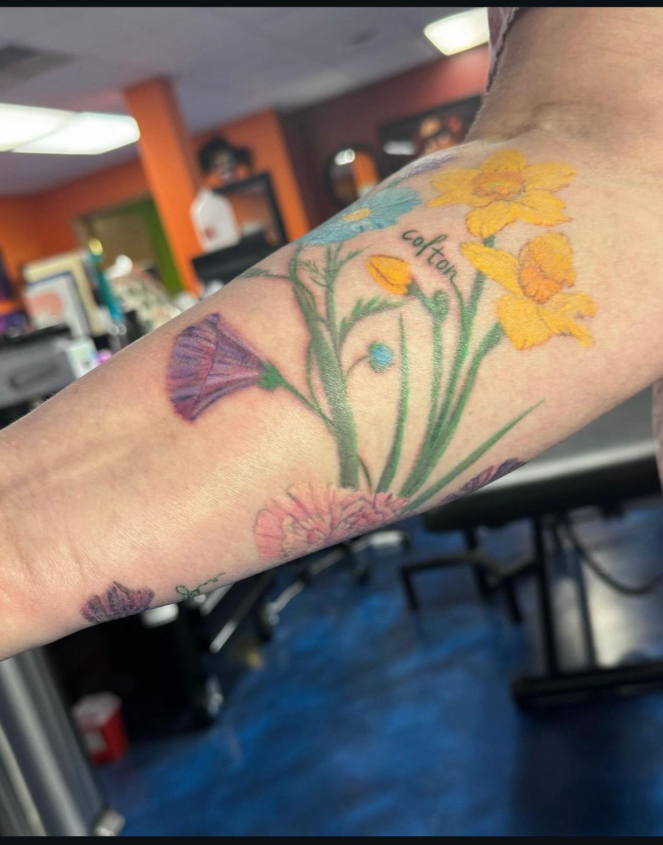 A woman has a tattoo of flowers on her arm