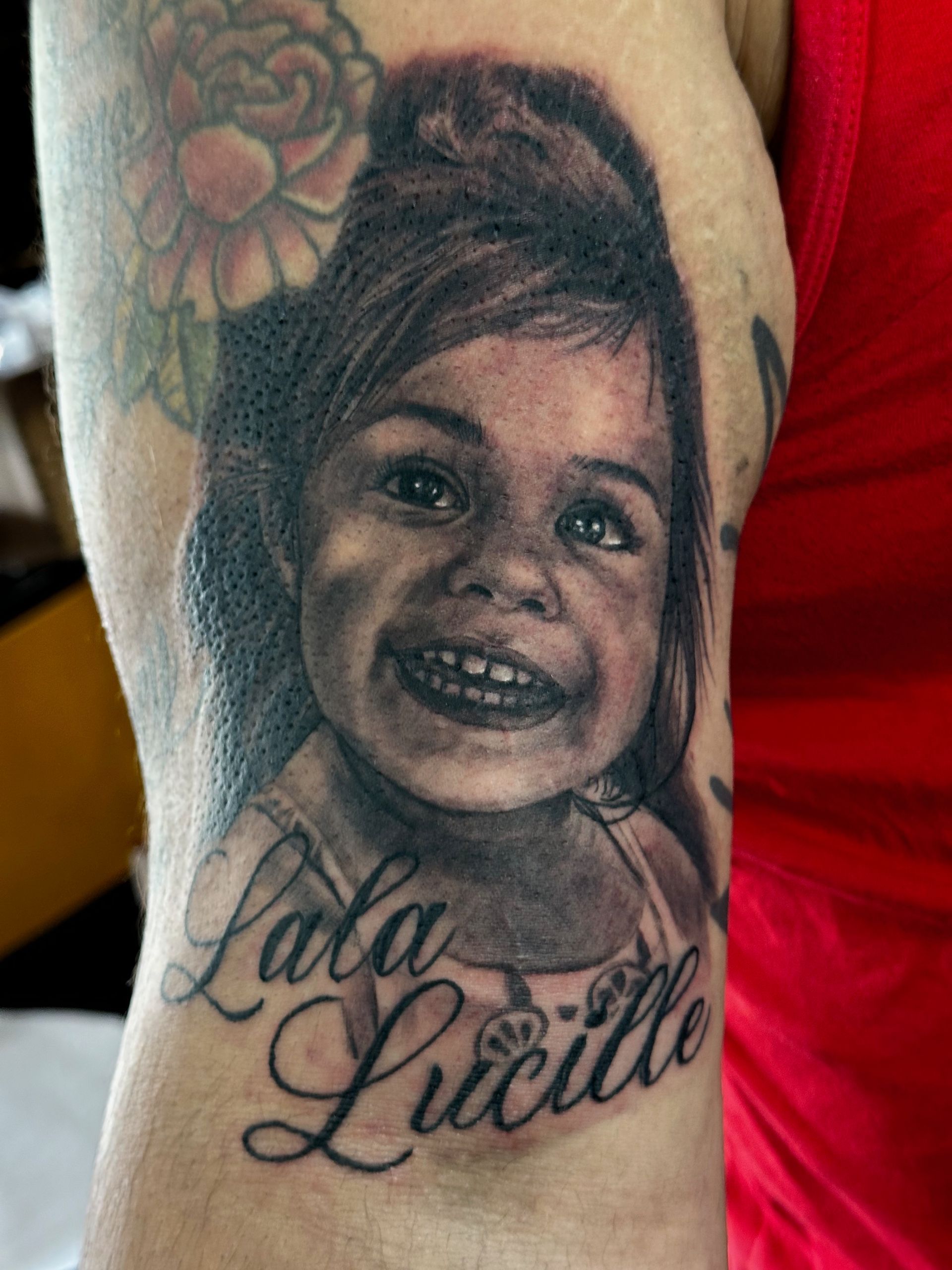 A tattoo of a little girl with the name lala lucille