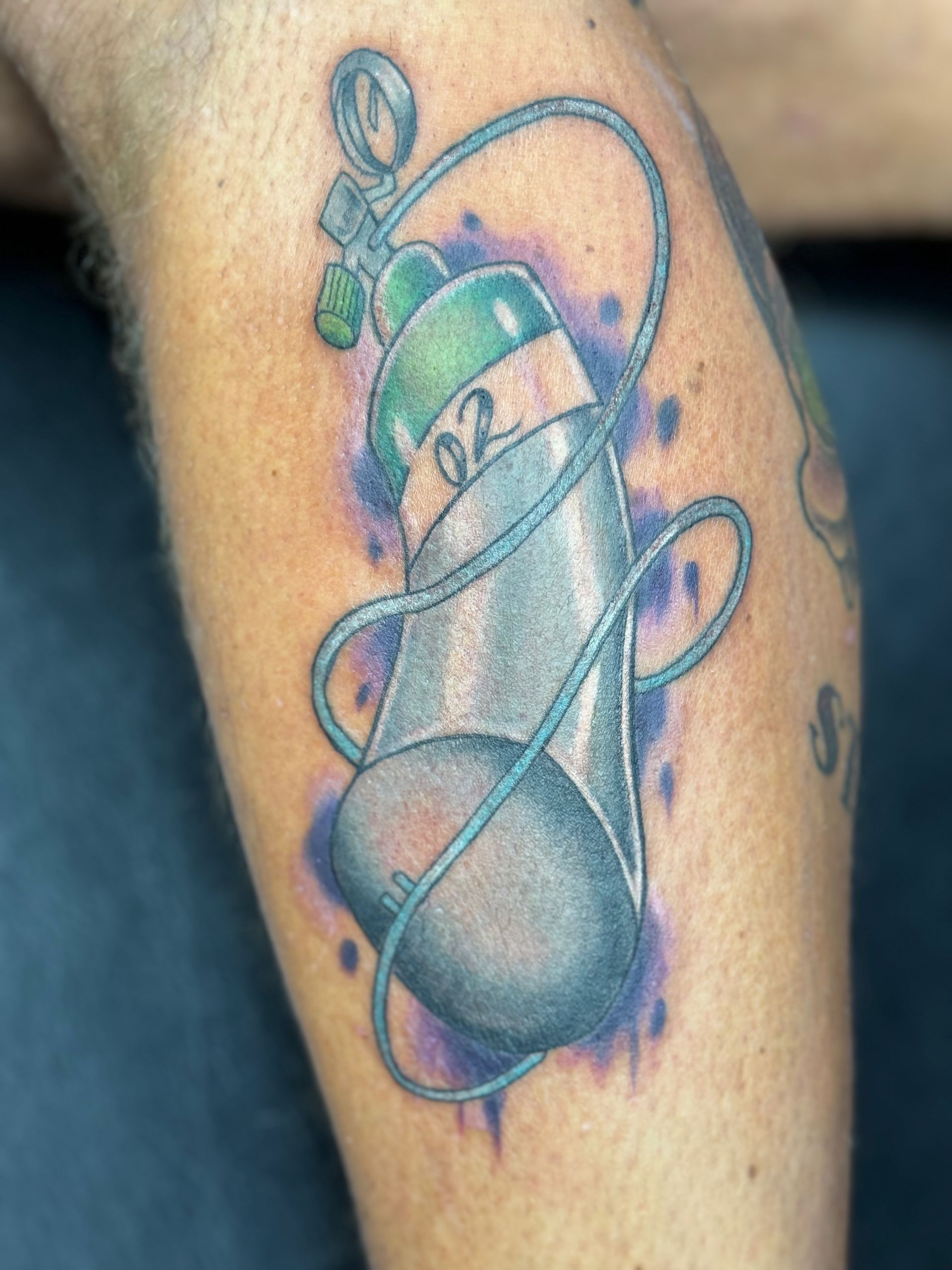 A person has a tattoo of an oxygen tank on their leg.